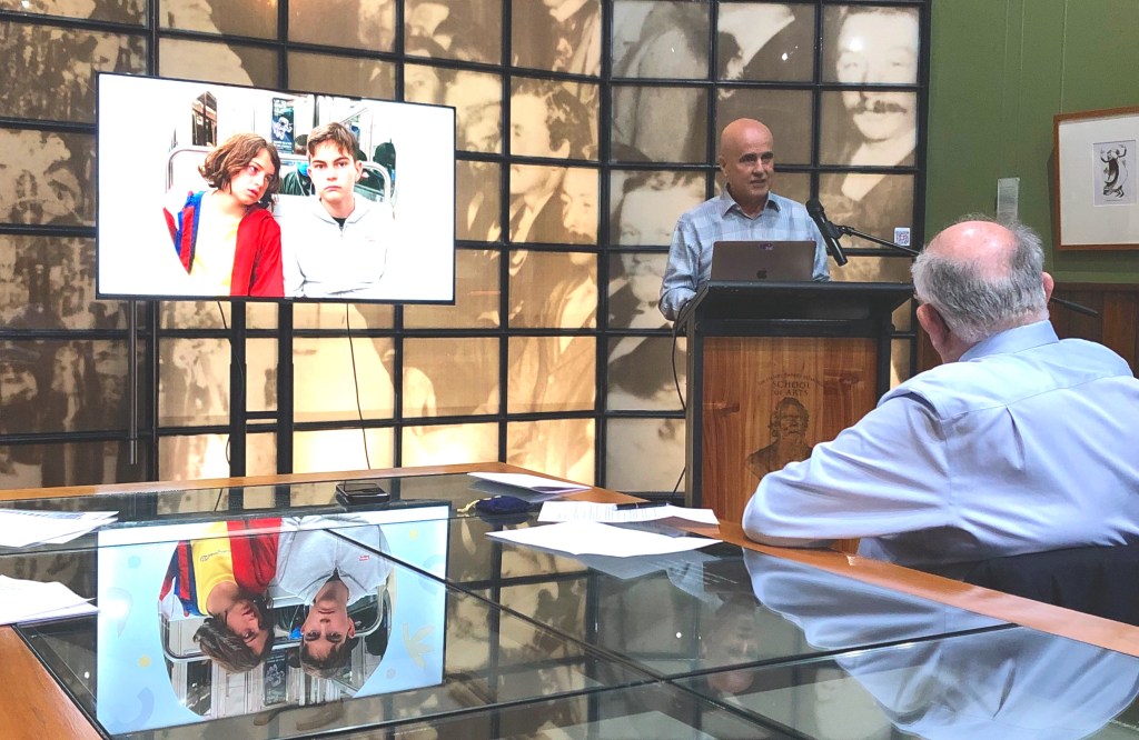 Adrian Piccoli displays an introductory slide showing young students